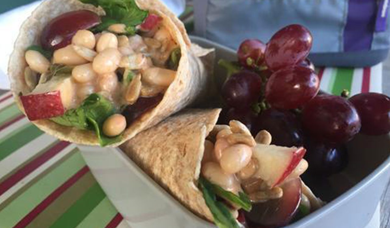 A close up of a wrap with grapes and nuts