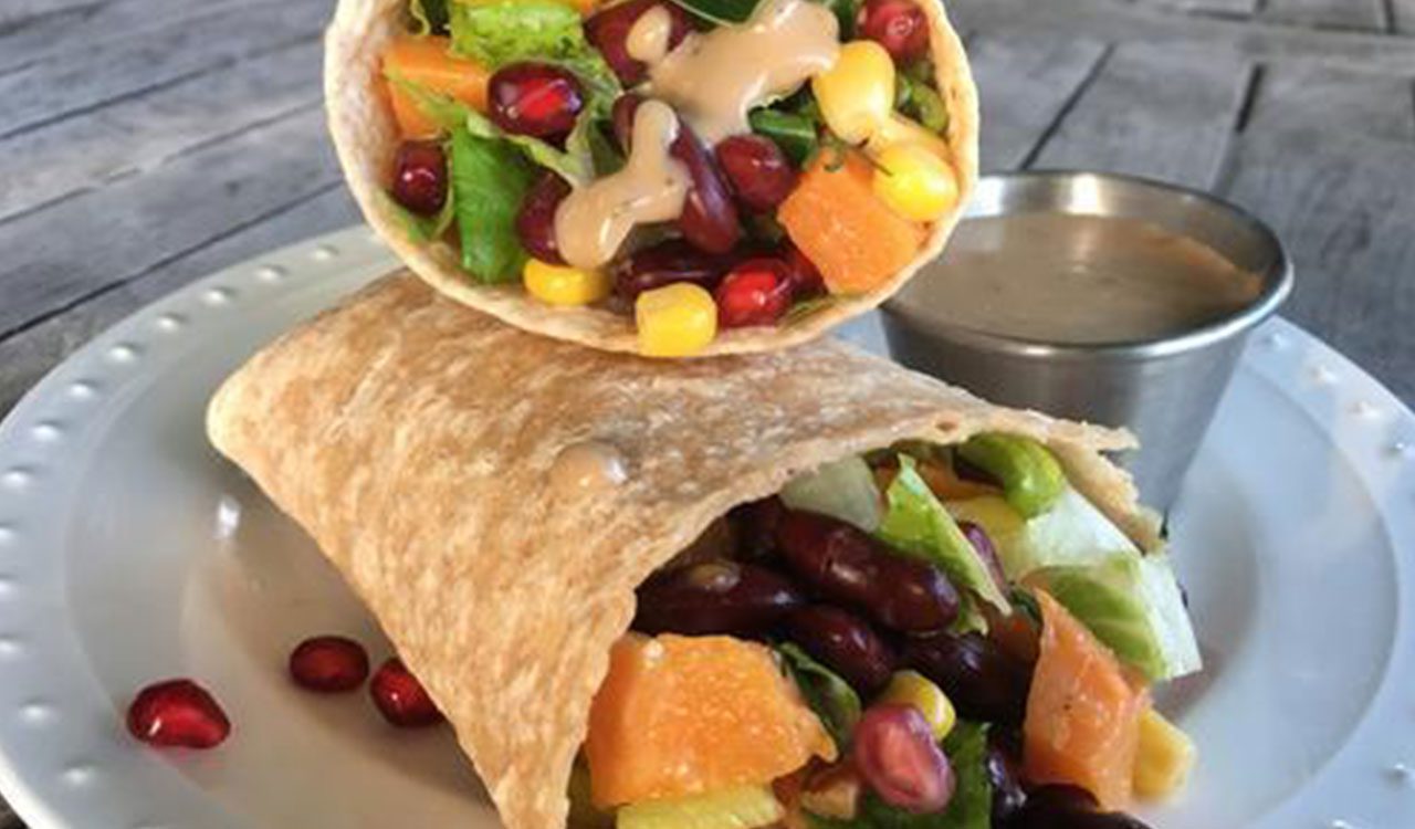 A burrito with beans and fruit on top of it.